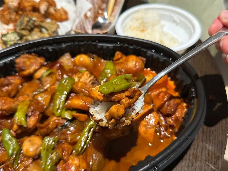 닭고기와 꽈리고추를 밥 위에 올려 한 입