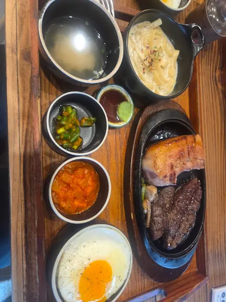 다양한 반찬과 함께 제공되는 스테이크 정식