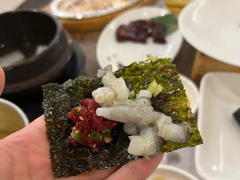 김에 뭉티기, 육회, 낙지를 싸서 먹는 모습