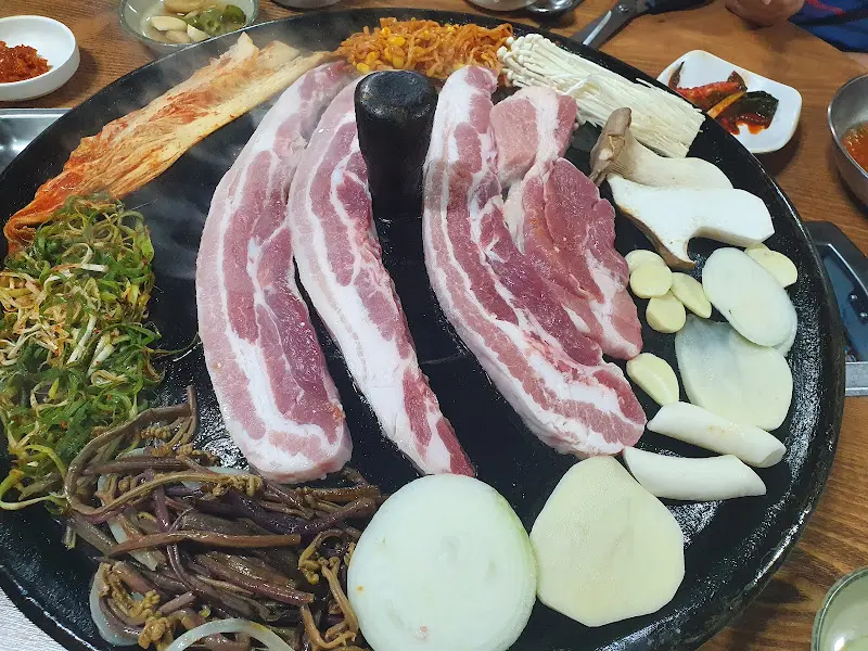 불판 위에서 구워지고 있는 냉동 삼겹살