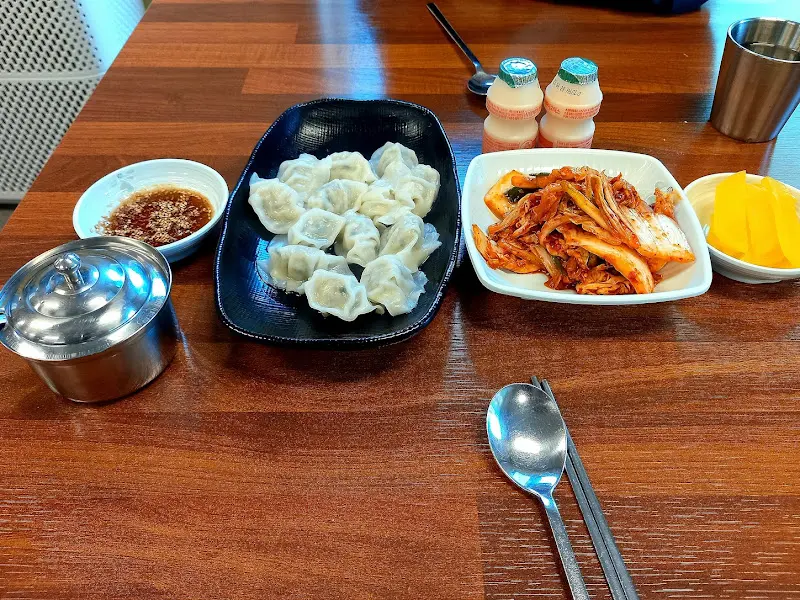 테이블 위에 놓인 물만두, 김치, 단무지, 그리고 요구르트