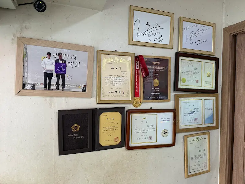 가게 내부 벽면에 걸린 상장과 사진들