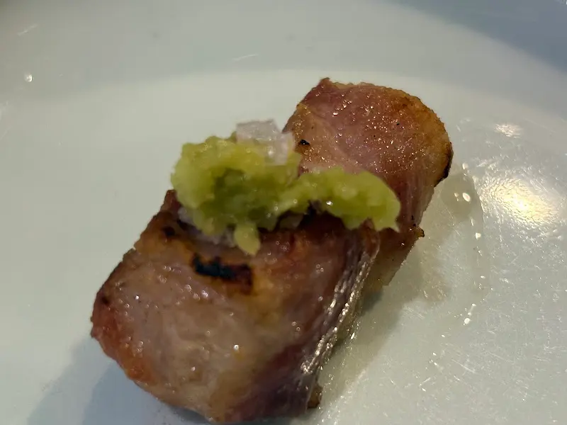 잘 구워진 고기 위에 와사비를 살짝 올려 먹는 모습