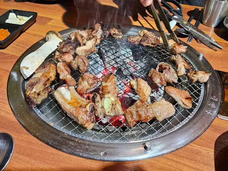 숯불 위에서 익어가는 돼지갈비와 버섯