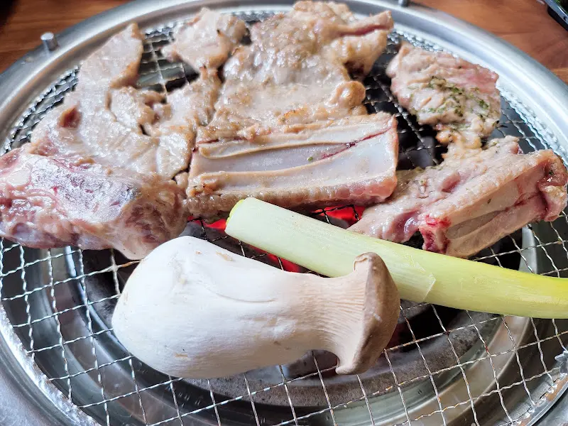 숯불 위에서 구워지는 돼지갈비와 버섯