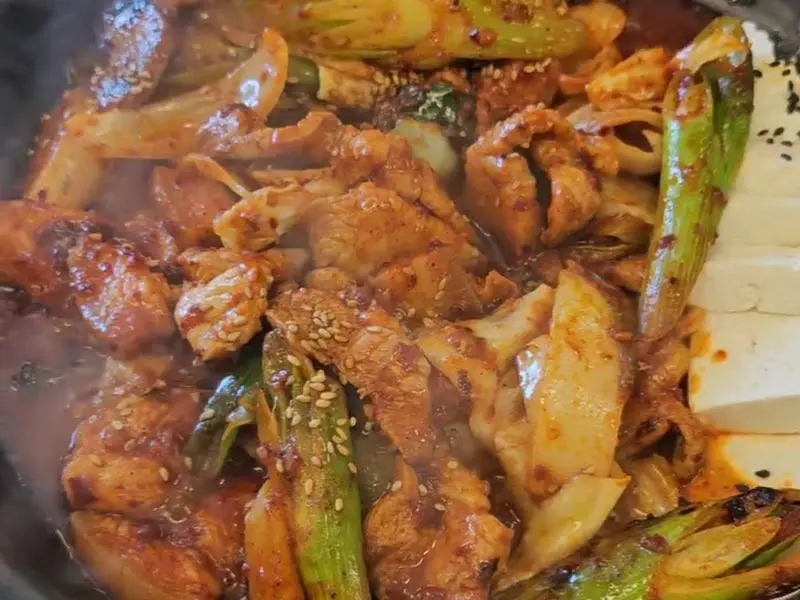 흑돼지 두루치기에 뿌려진 깨가 식감을 자극하는 사진