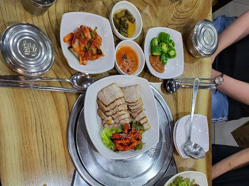 테이블 위에 놓인 보쌈과 다양한 밑반찬들. 푸짐한 양이 인상적이다.