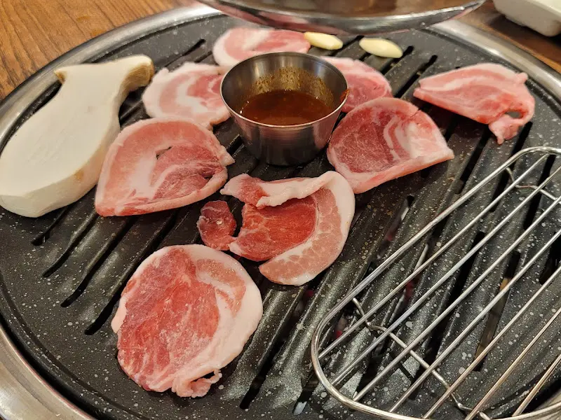 불판 위에 올려진 생고기와 버섯