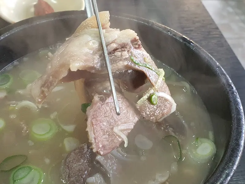 젓가락으로 집어 올린 윤기 흐르는 소머리 고기