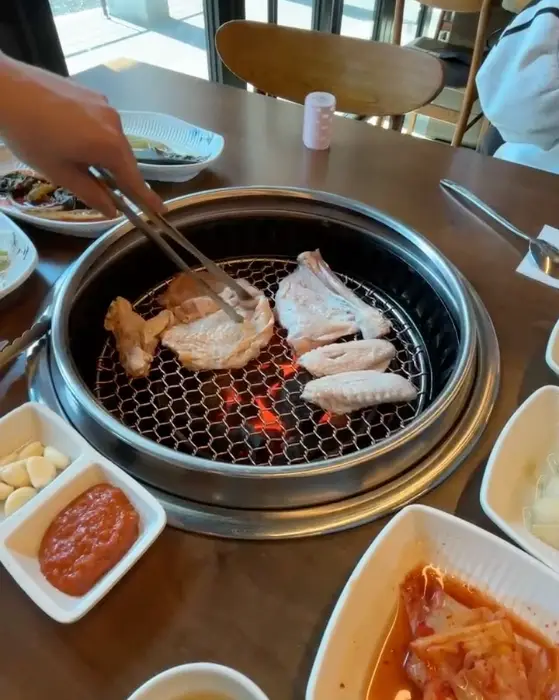 숯불 위에서 노릇하게 구워지고 있는 닭고기