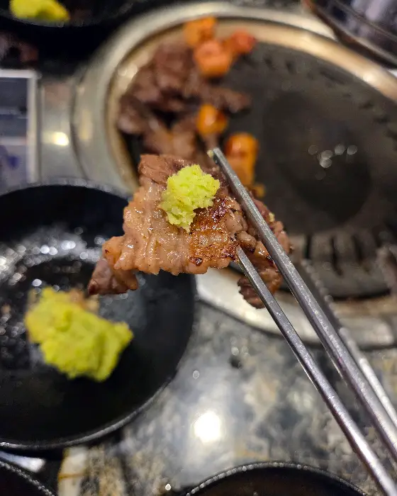 갓 구워낸 고기에 와사비를 곁들여 먹는 모습