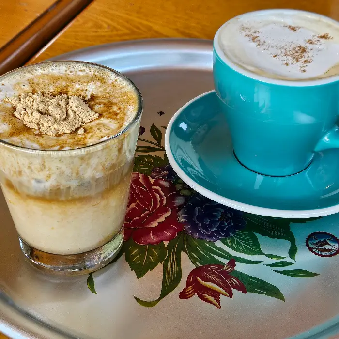 라떼와 컵에 담긴 음료 두 잔이 트레이 위에 놓여 있다.