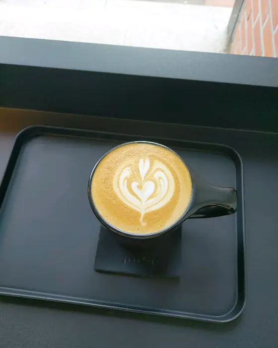 투명한 잔에 담긴 연두색 음료와 거품