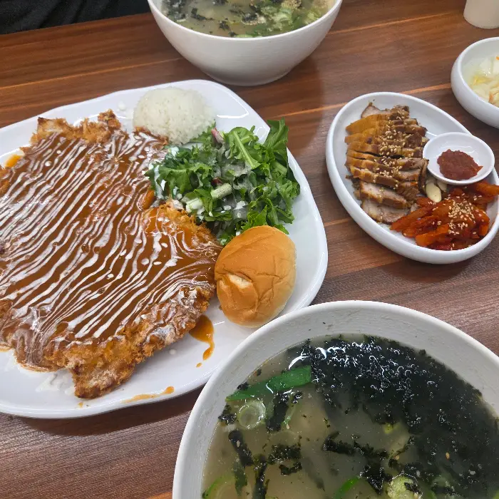 테이블 위에 놓인 다양한 음식들, 돈까스, 수육, 칼국수