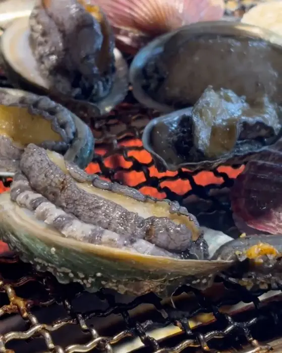 신선한 전복이 숯불 위에서 익어가는 모습