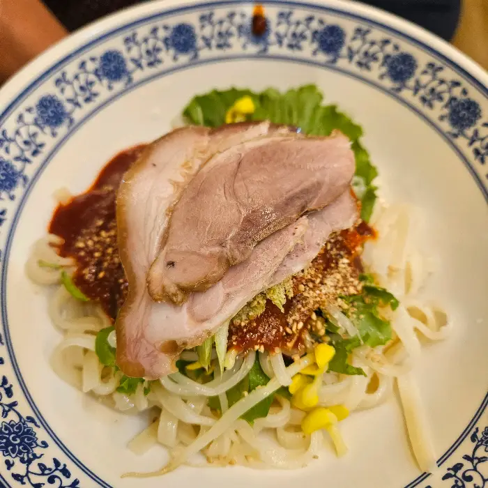 수육과 부추무침, 면이 어우러진 비빔칼국수 사진