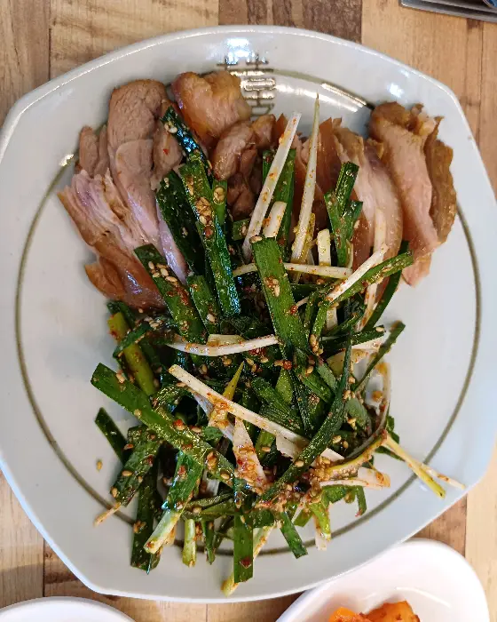 푸짐하게 차려진 수육과 곁들임 음식 사진