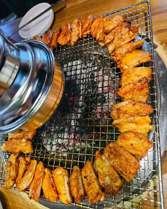 숯불 위 원형으로 놓인 양념 닭갈비