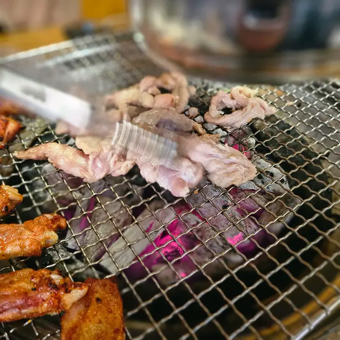 집게로 닭목살을 굽는 모습