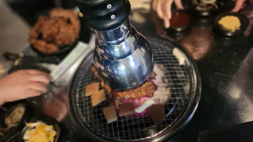 쪽갈비를 굽고 있는 테이블 위 모습. 조명과 함께 실내 분위기가 보입니다.