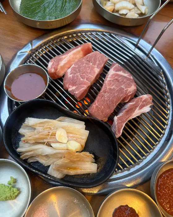 잘 익은 삼겹살 조각과 쌈무, 쌈장