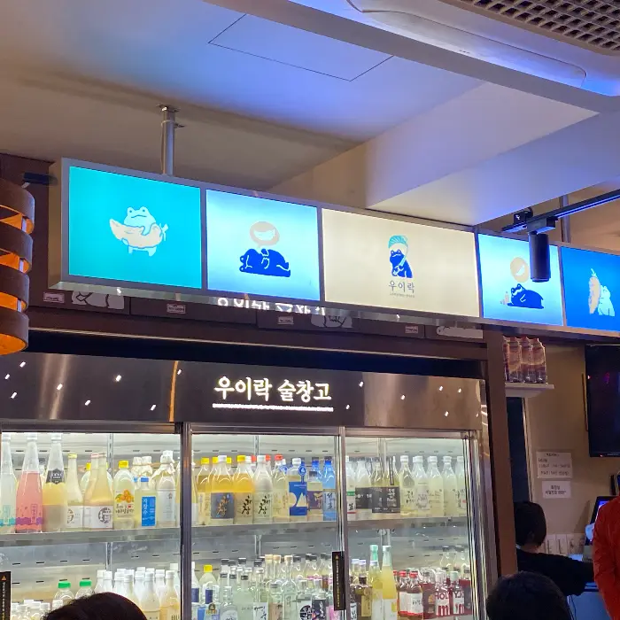 다양한 막걸리가 진열된 냉장고와 간판