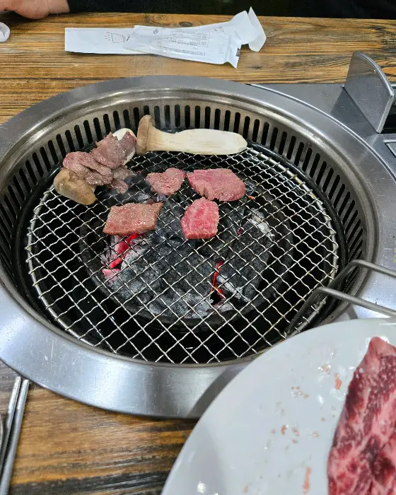 숯불 위에서 구워지고 있는 고기 조각들