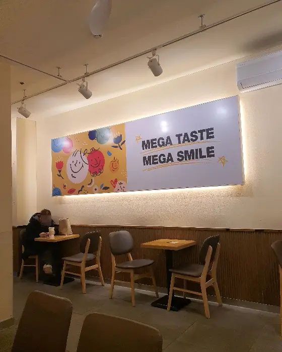 메가커피 컵홀더와 컵, 테이블 위에 놓여 있다.