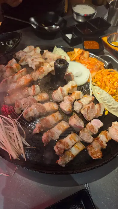 솥뚜껑 위에서 맛있게 익고 있는 돼지고기