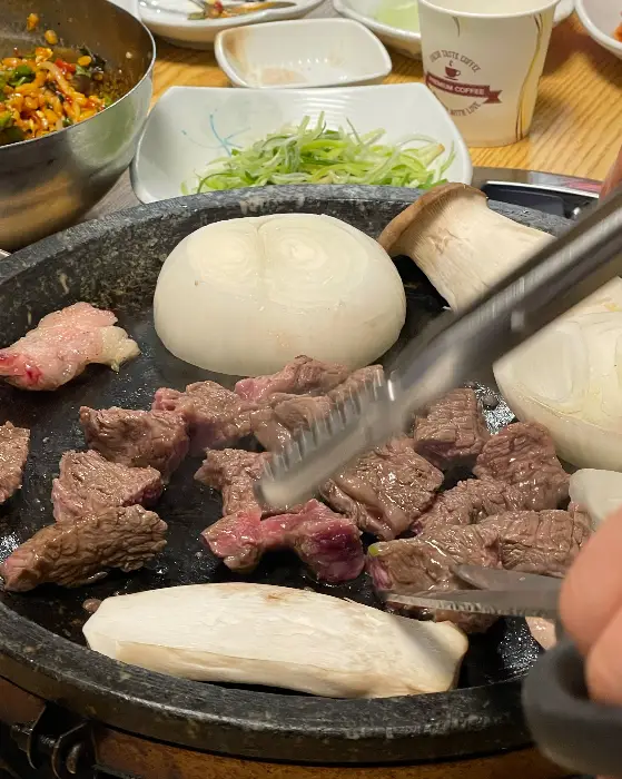 불판 위에 구워지는 신선한 고기와 버섯