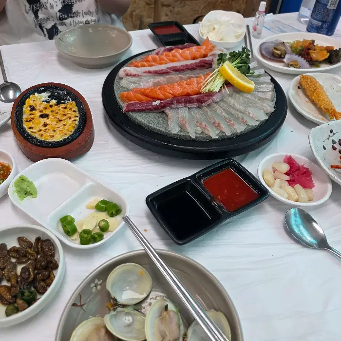 다양한 종류의 회가 돌판 위에 먹음직스럽게 담겨 있는 모습