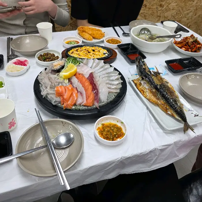 테이블에 놓인 다양한 해산물 요리와 곁들임 반찬들