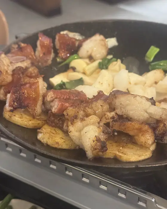 노릇하게 익은 곱창의 클로즈업 사진, 기름기가 윤기나게 빛나고 있다.