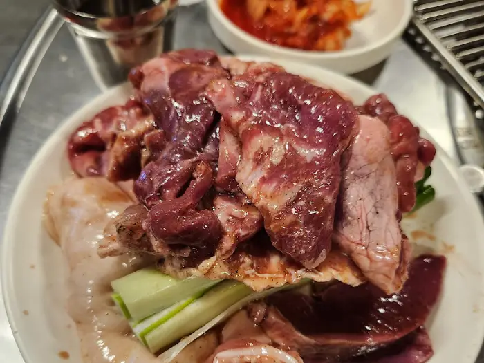 접시에 푸짐하게 담긴 다양한 부속구이와 채소
