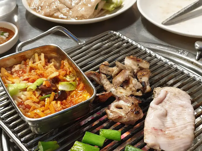 달궈진 불판 위에서 익어가는 부속구이와 찌개
