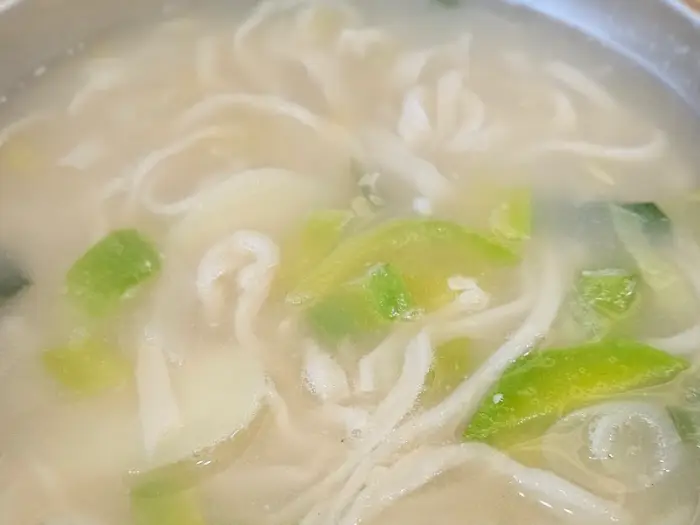 쫄깃한 면발과 함께 보이는 닭칼국수 국물