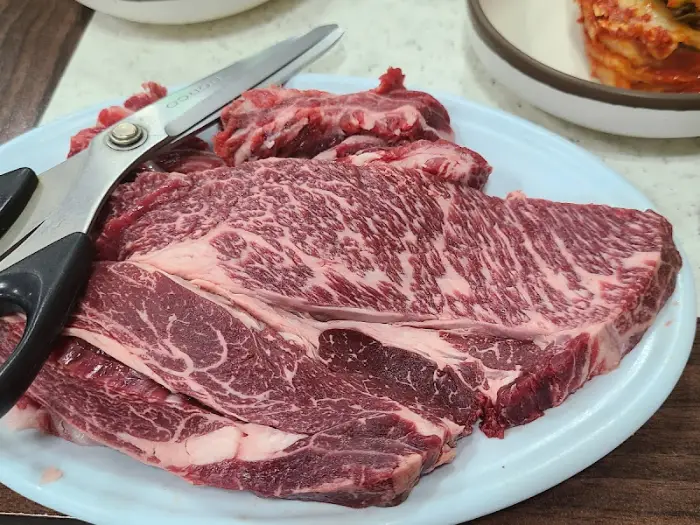 테이블 위에 놓인 가위와 한우 특수부위