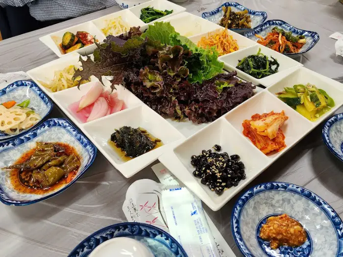 다양한 나물 무침과 쌈 채소가 담긴 접시들