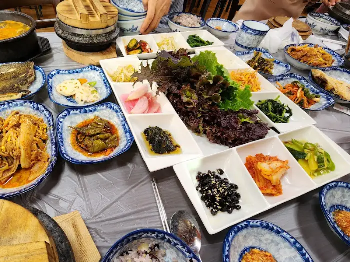 여러가지 반찬과 밥, 쌈 채소가 놓인 테이블 전체 모습