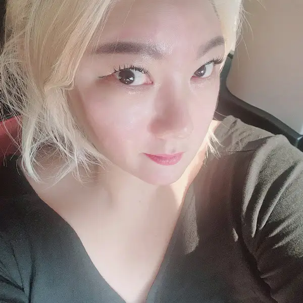 한 여성이 카메라를 보며 미소 짓는 모습