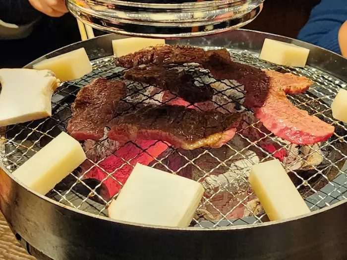 숯불 위에서 구워지고 있는 와규와 버섯 조각들