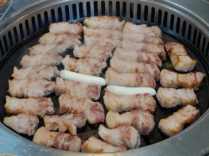 불판 가득 구워지고 있는 삼겹살과 떡
