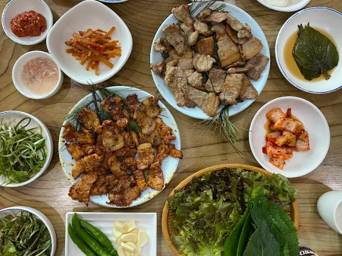 다양한 종류의 숯불구이와 곁들임 반찬, 쌈 채소 모습