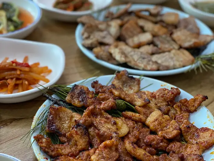 윤기 나는 숯불구이 접시와 주변의 반찬들