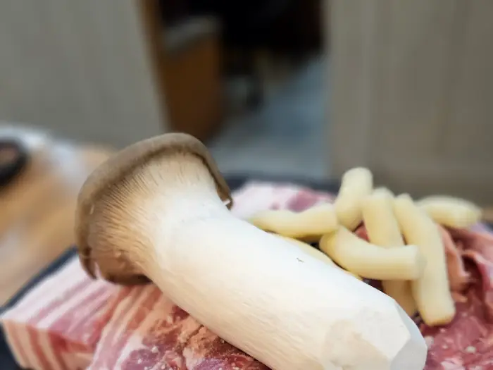 통삼겹살 위에 놓여있는 새송이버섯과 떡