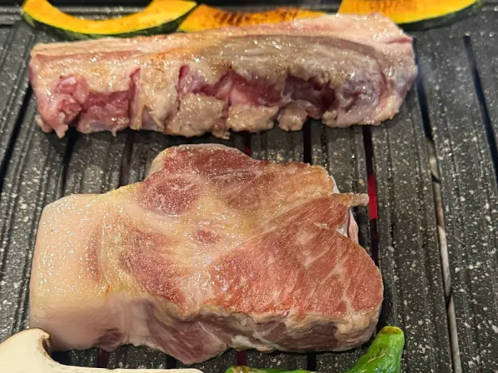 그릴 위에 올라간 흑돼지 삼겹살과 목살