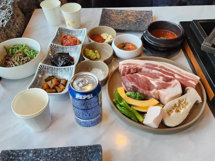 테이블 세팅 모습: 흑돼지, 밥, 멜젓, 밑반찬, 음료수