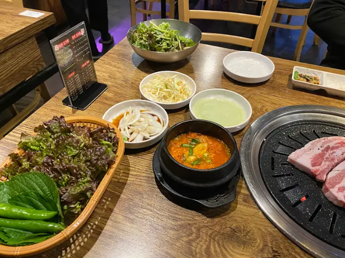 테이블에 차려진 다양한 음식들, 샐러드, 쌈채소, 된장찌개 등