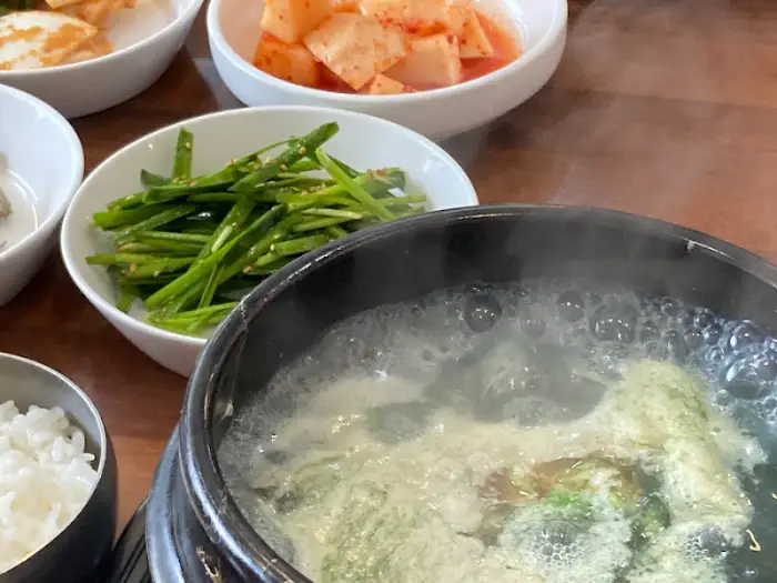 테이블에 차려진 다양한 밑반찬과 굴국밥
