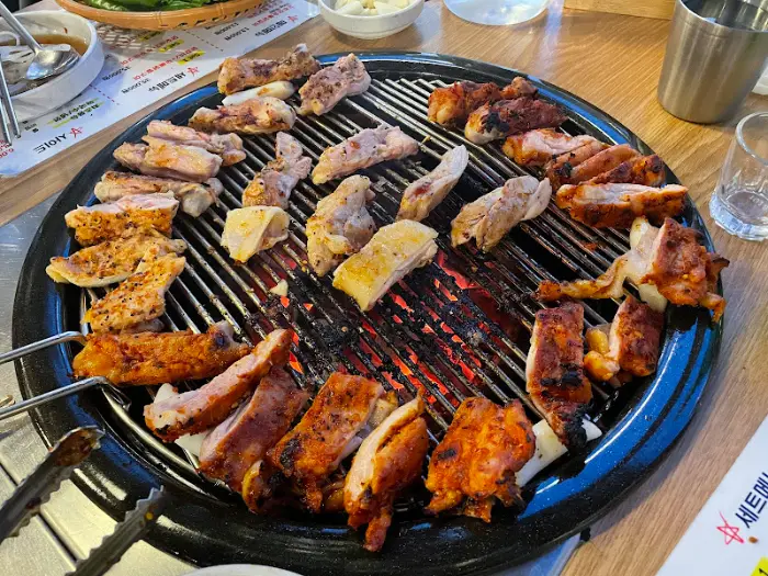 다양한 부위와 양념의 닭갈비가 숯불 위에서 익어가는 모습